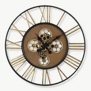 Large steampunk wall clock with spinning golden gears on a living room wall