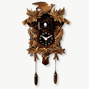 Antique cuckoo wall clock in Black Forest style mounted on a white wall