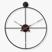 Crossed circle design metal wall clock in black, 50 cm, mounted on a white wall