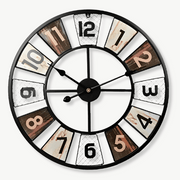 Colorful industrial wall clock with bold Arabic numerals on a white wall