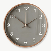 Scandinavian solid wood wall clock in white on a light living room wall