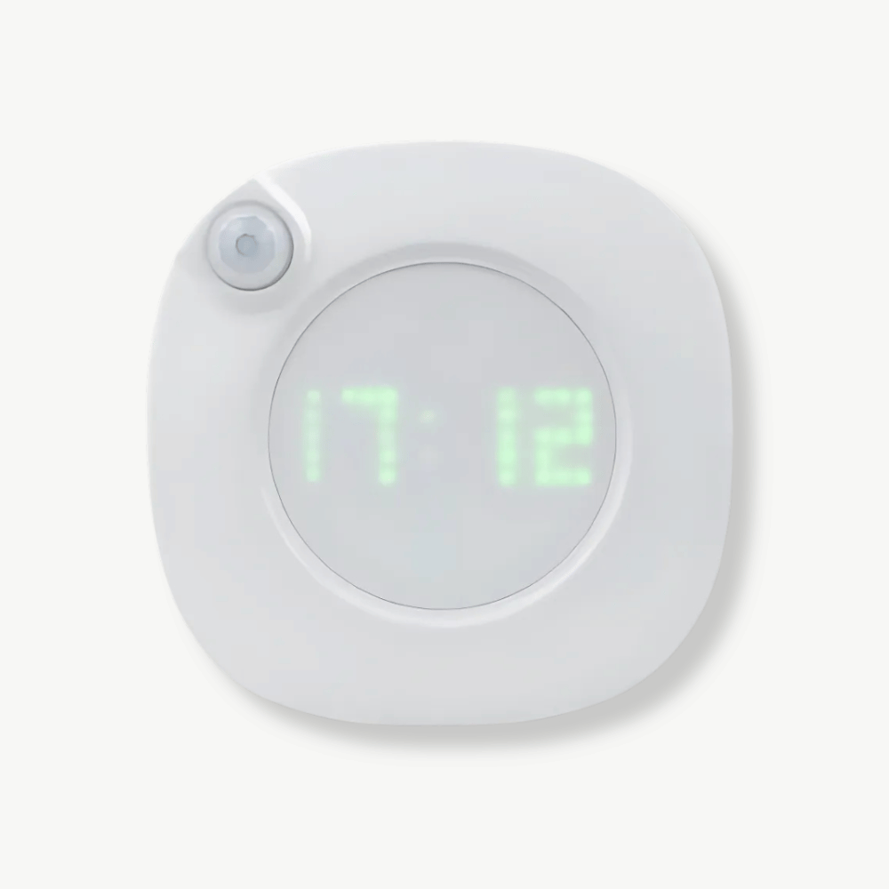 Motion-activated digital wall clock with LUMINOVA display on white wall