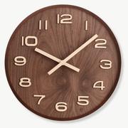 Handcrafted walnut wood wall clock with silent analog movement on a white wall