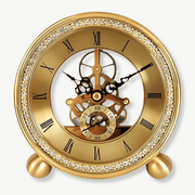 Golden brass tabletop clock with exposed mechanism on a wooden desk