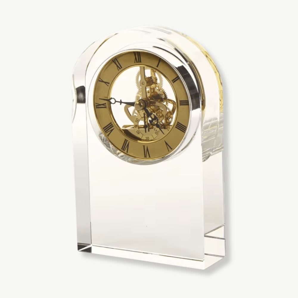 Transparent glass and crystal desk clock with antique design on a wooden desk