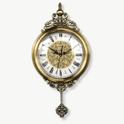 Vintage metal wall clock with Roman numeral dial and glass mirror accent