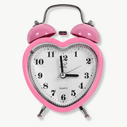 Pink heart-shaped alarm clock with double bell on white background
