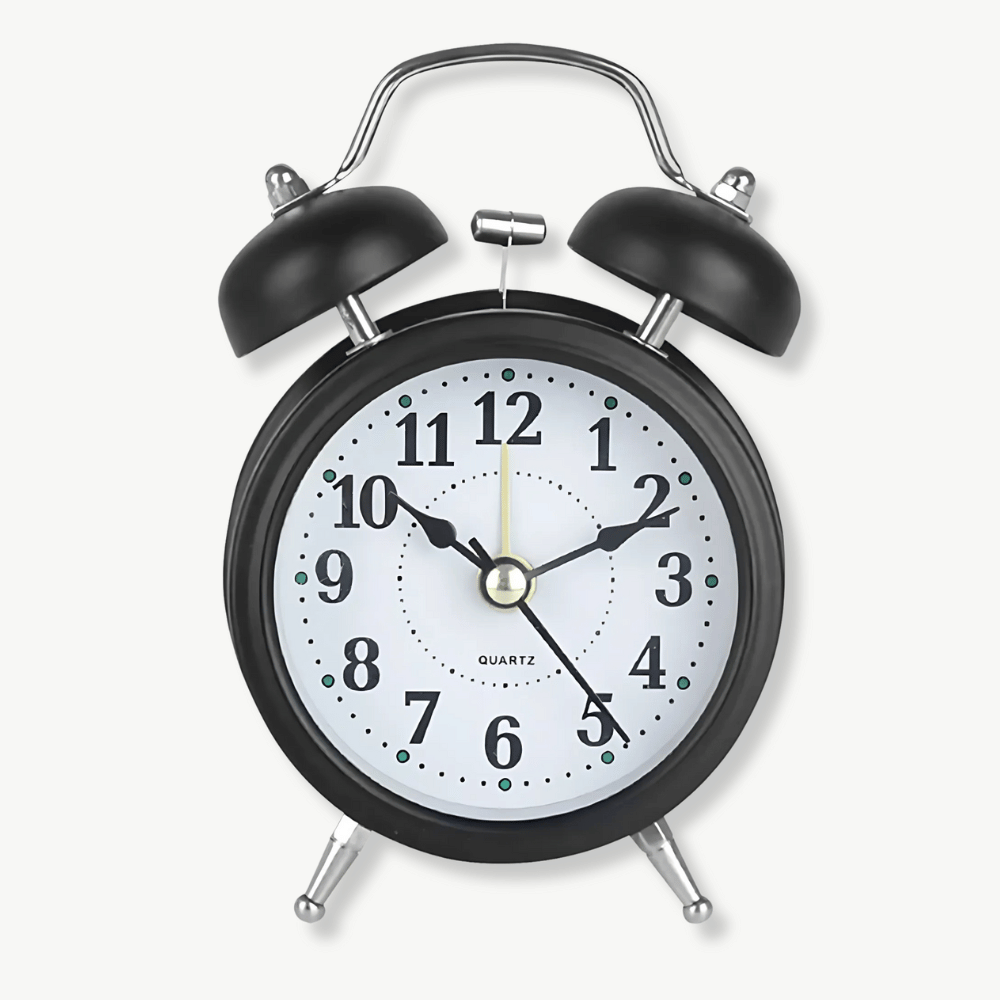 Retro quartz double bell alarm clock in black metal on a bedside table