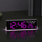 LED digital alarm clock with ambient light glowing on a bedside table