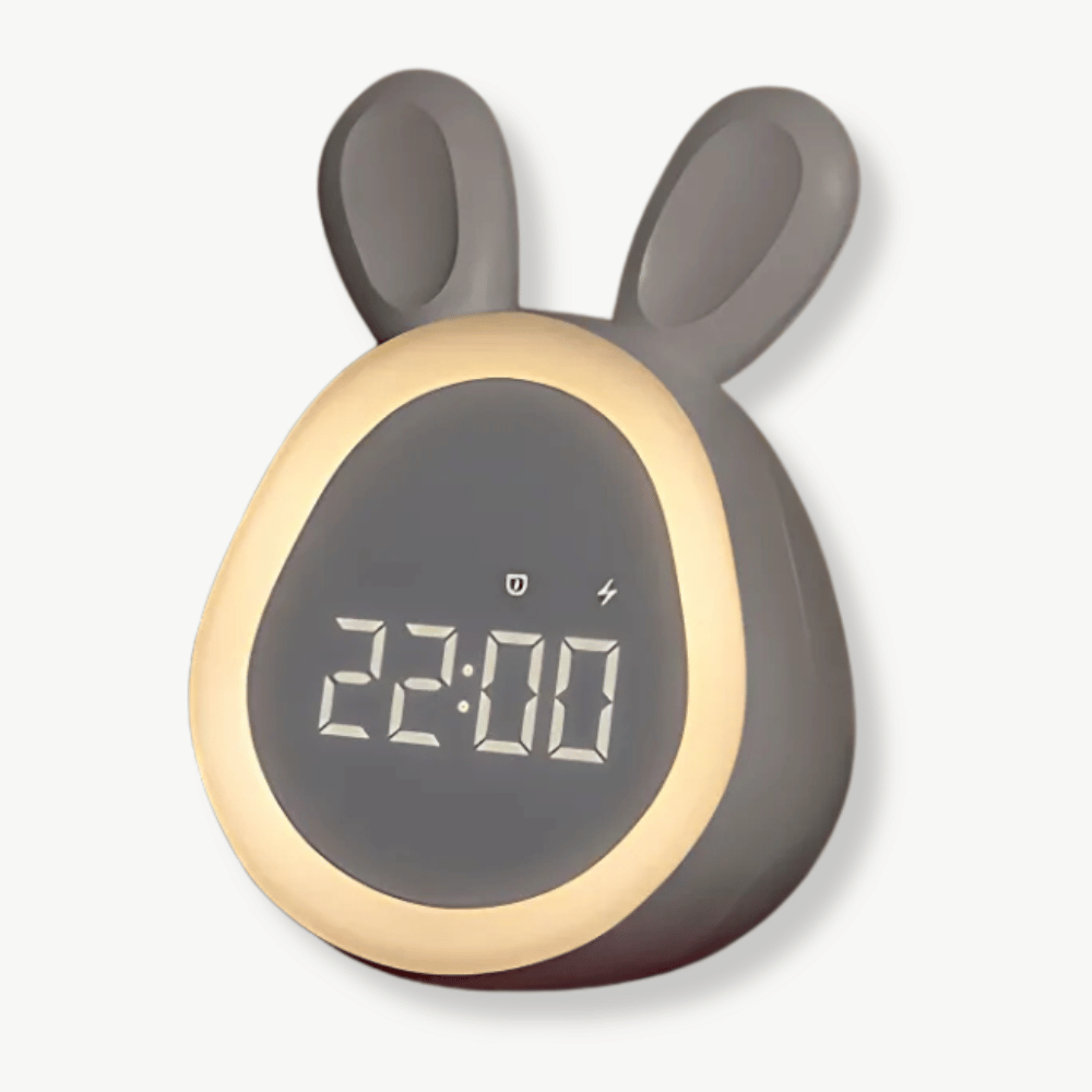 White bunny alarm clock with LED display glowing on a nightstand