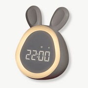 White bunny alarm clock with LED display glowing on a nightstand