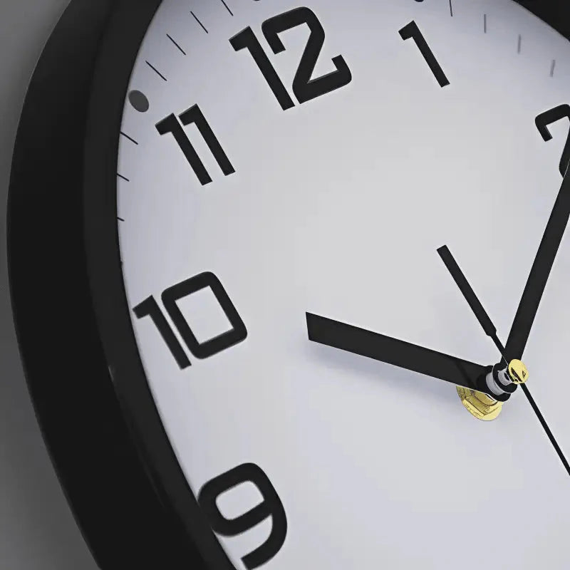 Close-up of analog clock face showing hour and minute hands on black clock