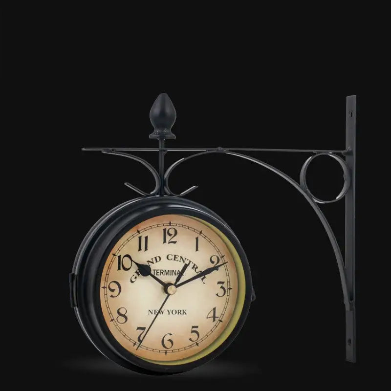 Double-sided wall clock mounted on decorative scroll bracket with fleur-de-lis detail