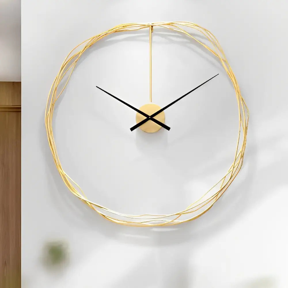 Geometric gold metal wall clock against a light wall