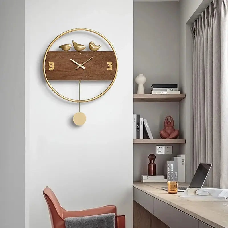 Gold metal analog wall clock with swinging pendulum and bird accents