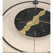 Black and gold Kintsugi metal wall clock with abstract pattern on white wall