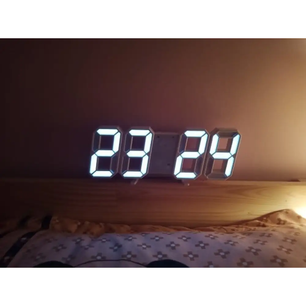LED clock in night mode with dimmed display in dark bedroom setting