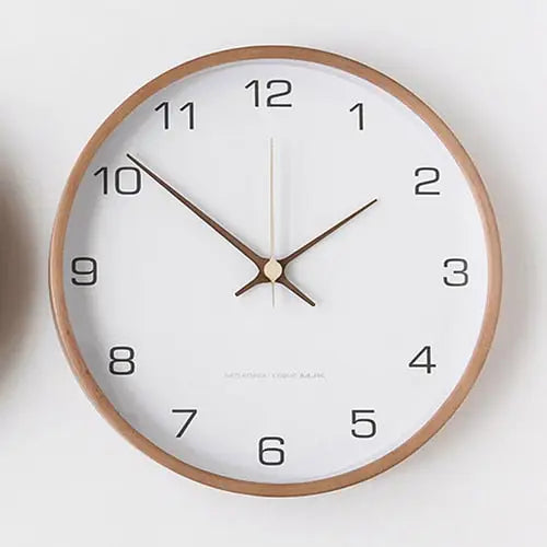 White Nordic wall clock styled above a sofa in a Scandinavian living room