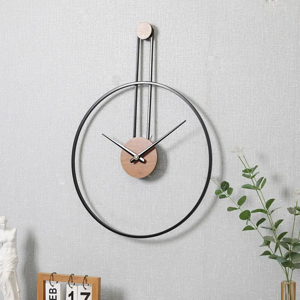 Silver minimalist circle wall clock hung above a modern sofa