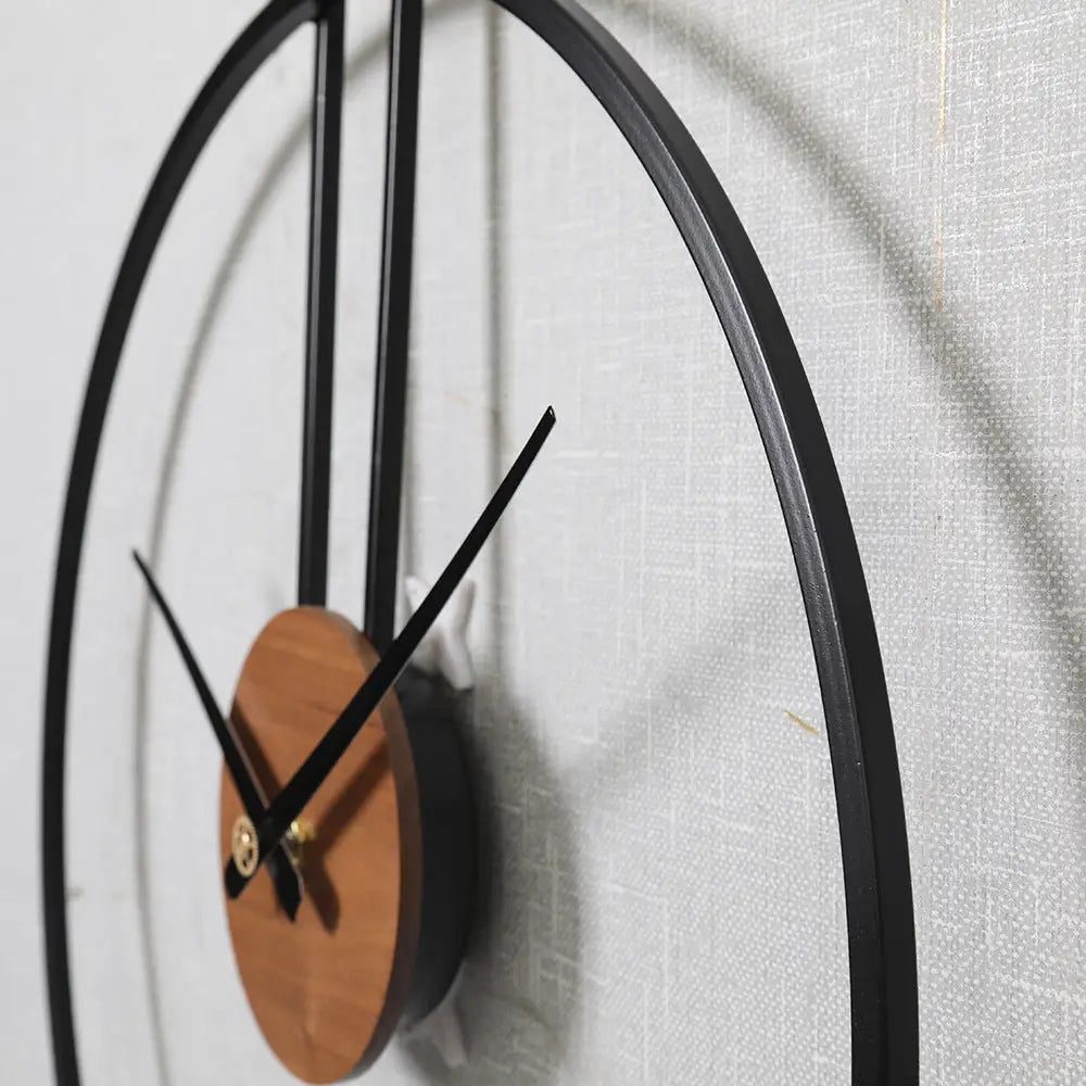 Suspended circle wall clock in black next to a bedroom headboard
